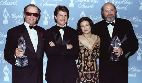 Reuters Reiner and Jack Nicholson holding People's Choice Awards alongside, Tom Cruise and Demi Moore in front of blue People's Choice Awards branding